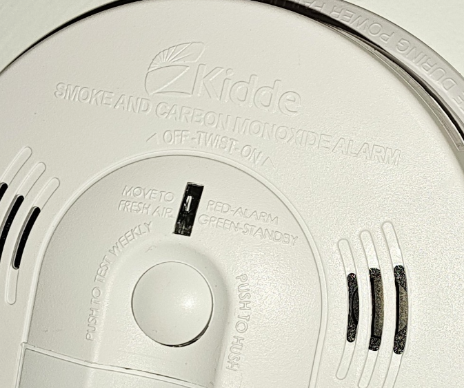 Kidde 120V combination smoke and carbon monoxide alarm, ceiling-mounted with labeled test and reset features.