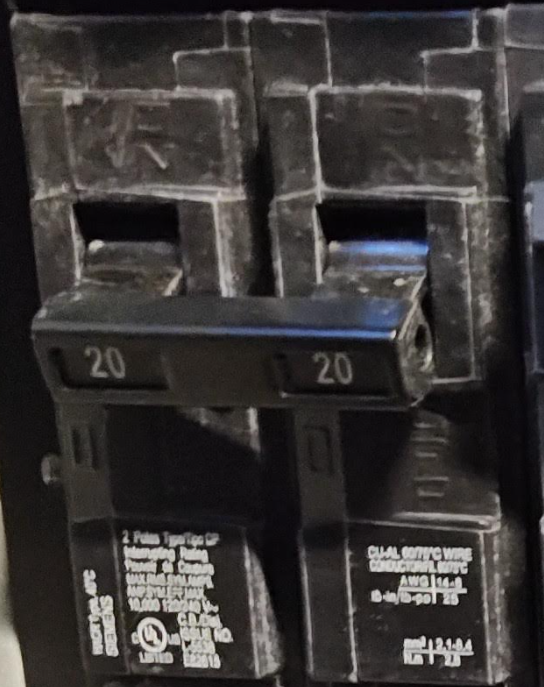 Close-up of dual 20-amp circuit breakers with handle tie, code-compliant for multi-wire branch circuits with shared neutral
