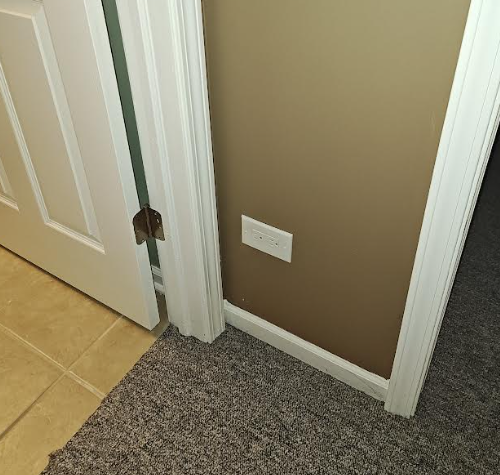 Close-up of electrical outlet installed in 24" wall section, meeting code for minimum spacing.