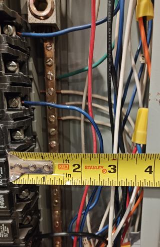 "Wire nuts in service panel enclosure showing conductor spacing and NEC 312.8 calculation area."