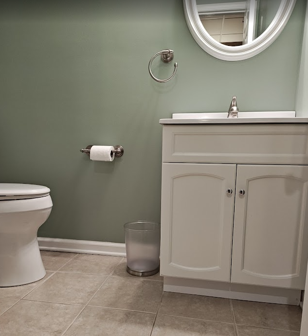 Bathroom fixture spacing requirements shown by vanity and mirror layout in a small residential bathroom