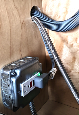 Electrical box with GFCI-protected outlet and flexible conduit for appliance wiring per 2023 NEC