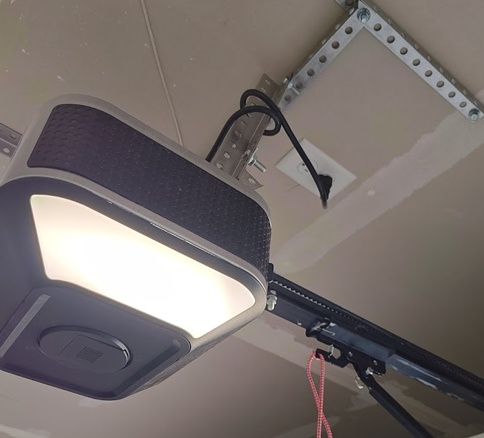 Garage ceiling-mounted outlet powering a door opener, highlighting GFCI requirements for garage circuits