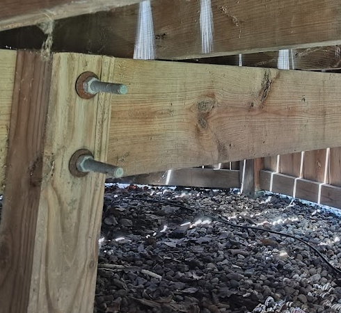 Angle view Side-mounted deck beam connection fastened to an unnotched 4x4 post with through-bolts.