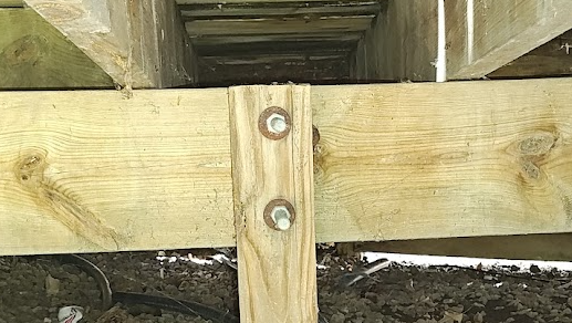 Traditional deck beam to post connection using through-bolts attached to the side of a 6x6 post.