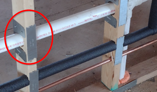 Stud shoe circled in red around a pipe penetration, with protective nail plates at other locations